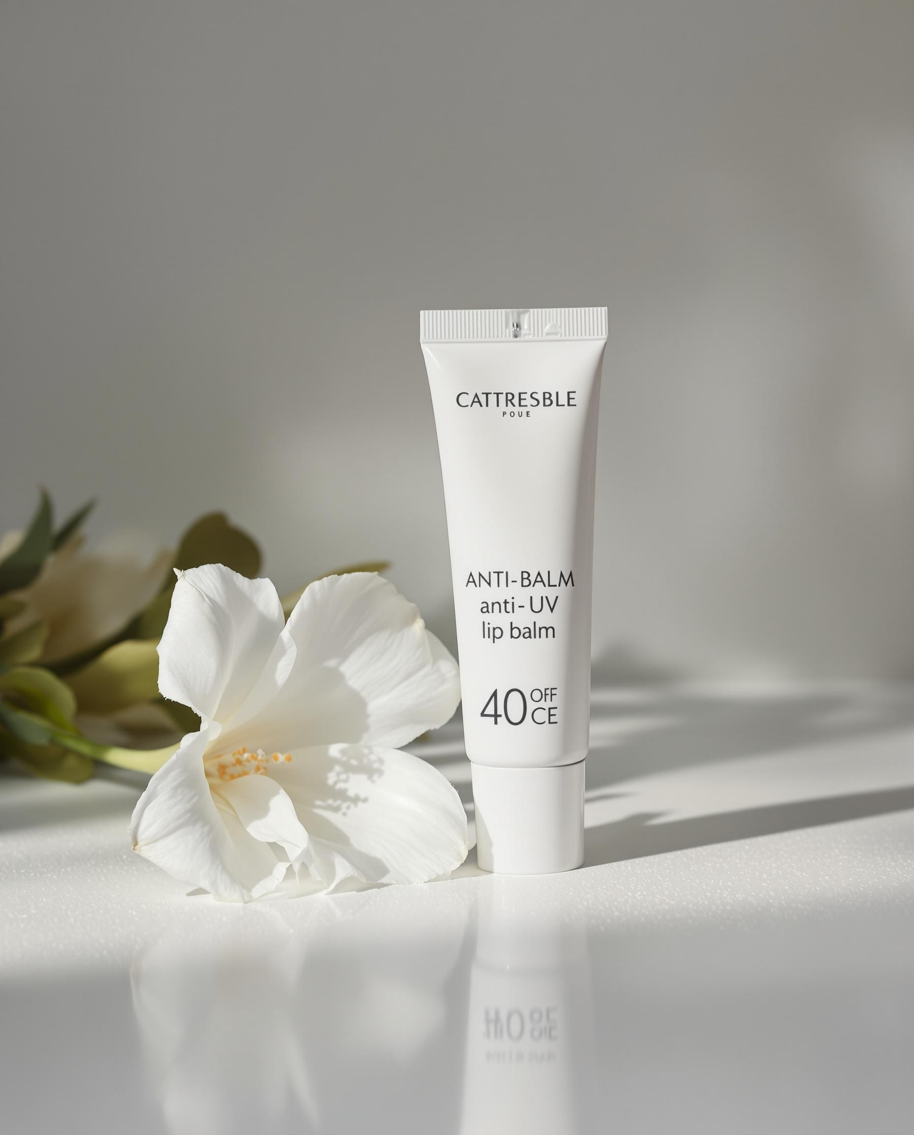 Tube de baume à lèvres anti-UV avec une fleur blanche en arrière-plan