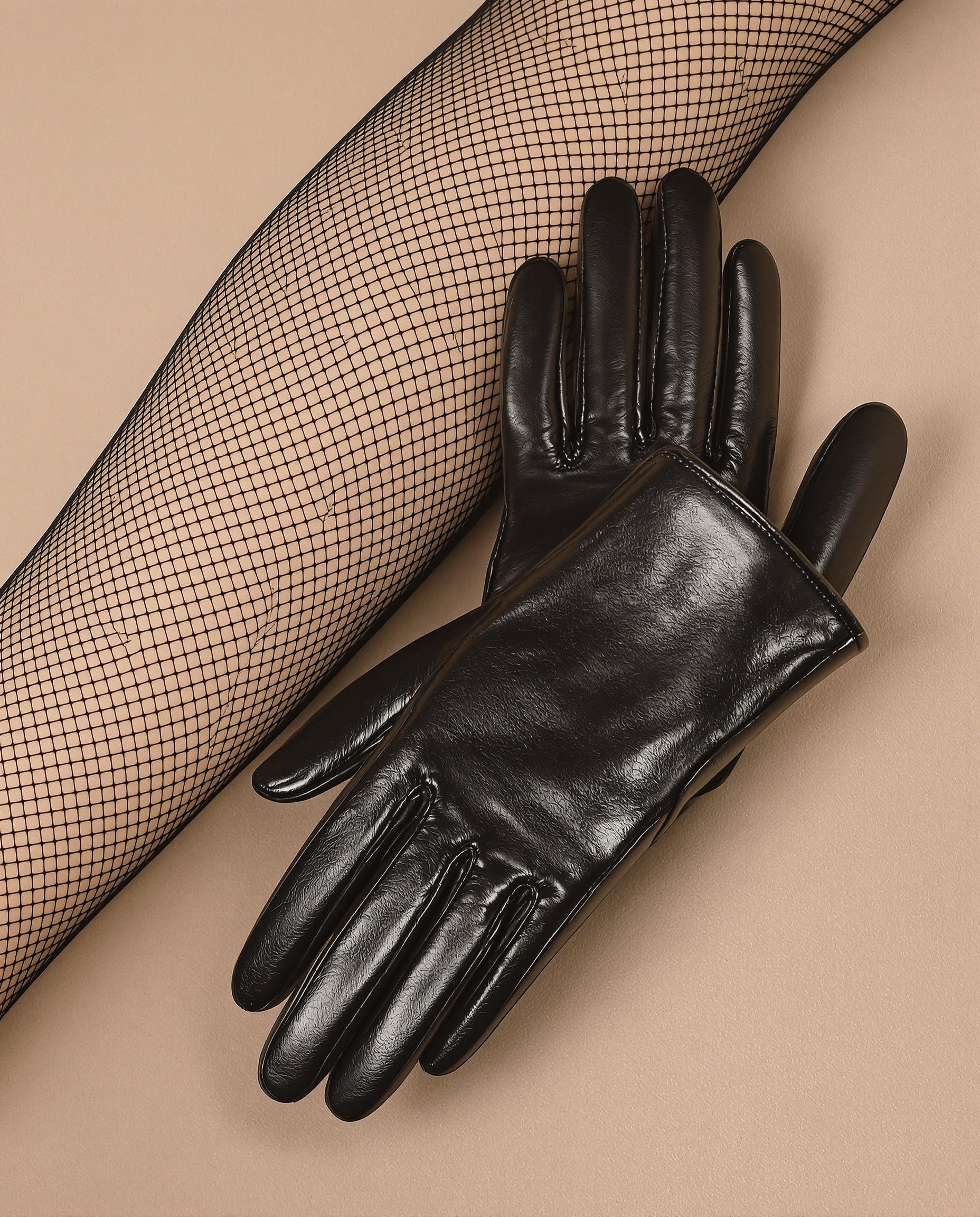 Paire de collants résille et gants en cuir noir posés côte à côte.